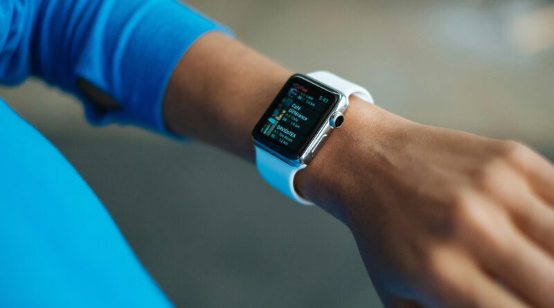 Focus on a smartwatch worn on an adult's wrist, showcasing its digital display.